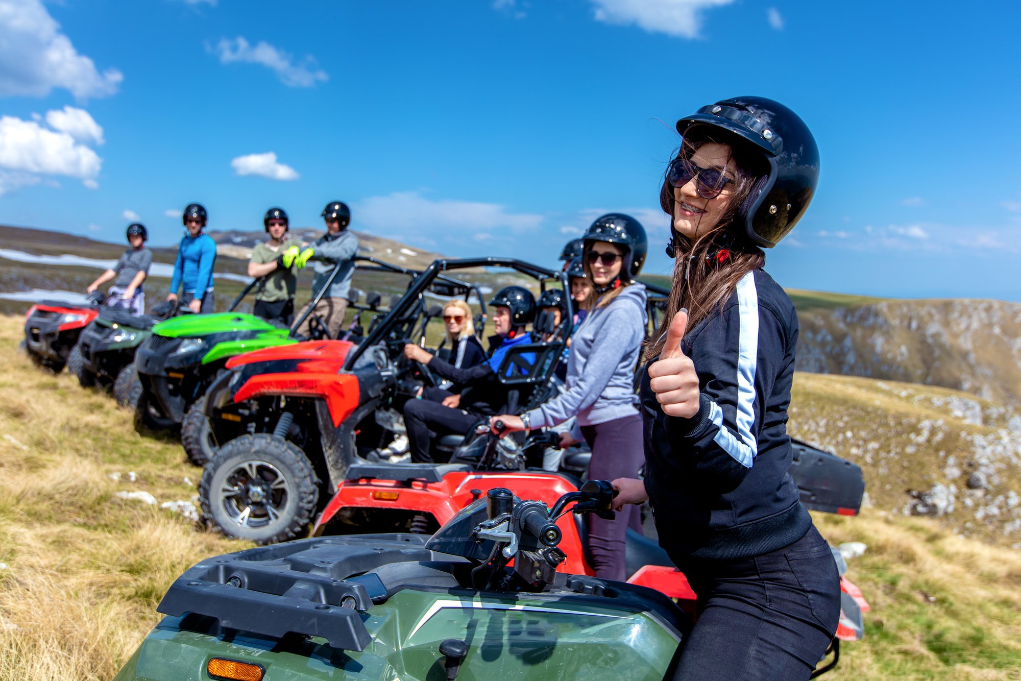 Friends driving off-road with quad bike or ATV and UTV vehicles